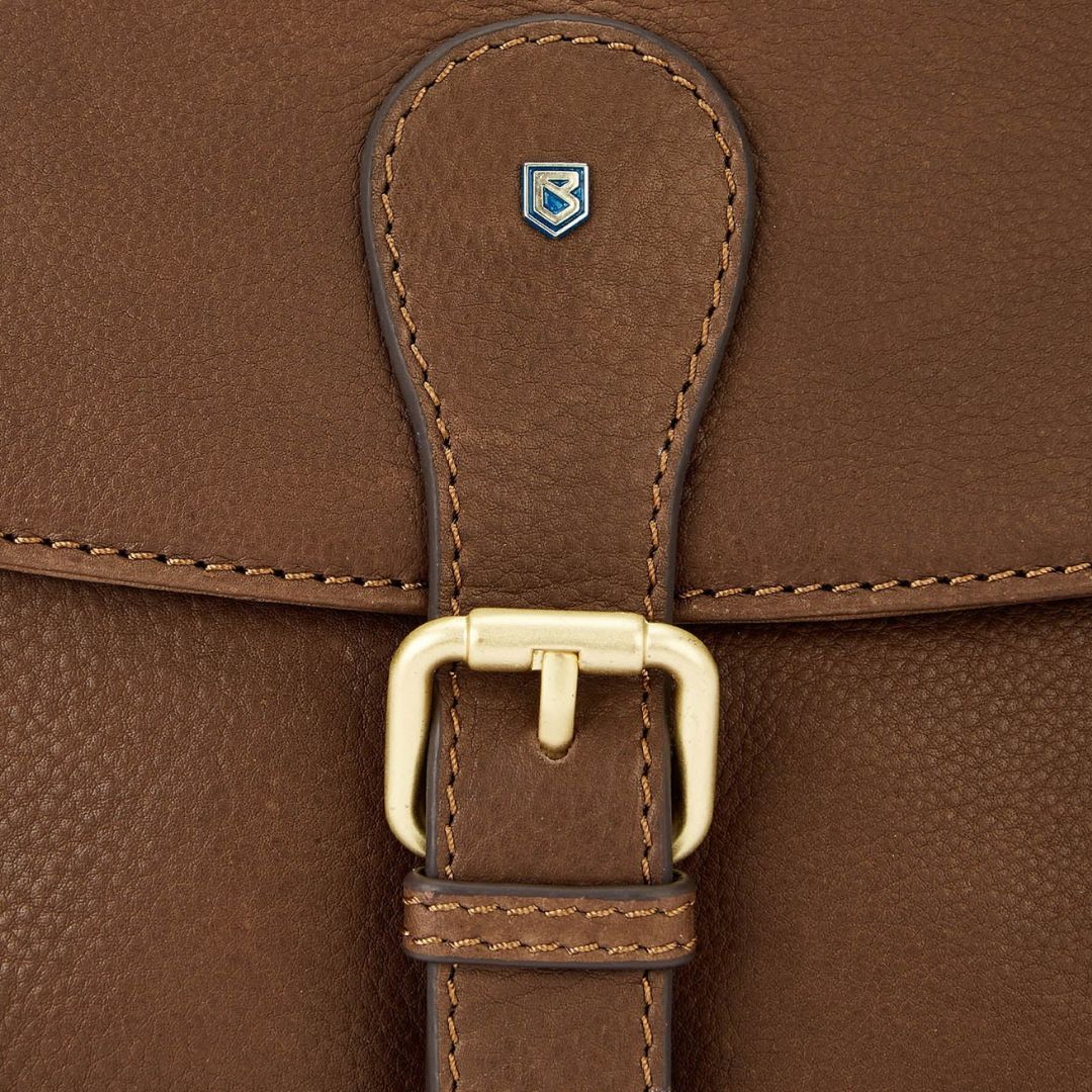 Close-up of a brown leather bag with a gold buckle and visible brand logo.