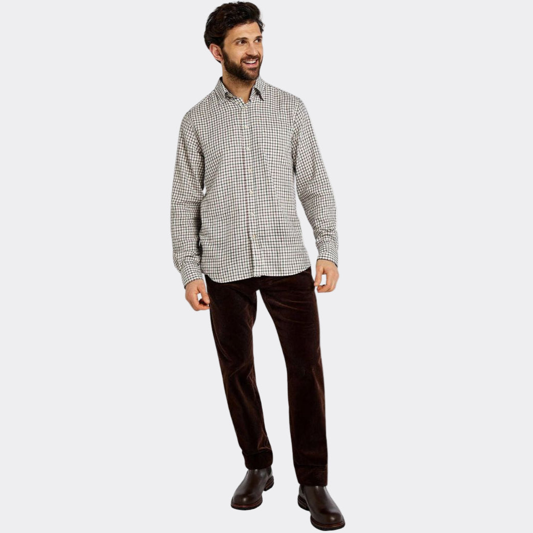 Man wearing a checkered shirt and dark pants on a white background