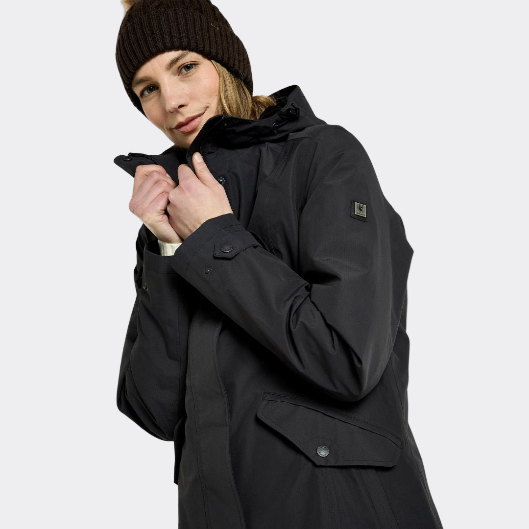 Person wearing a black coat with a brand logo on a white background