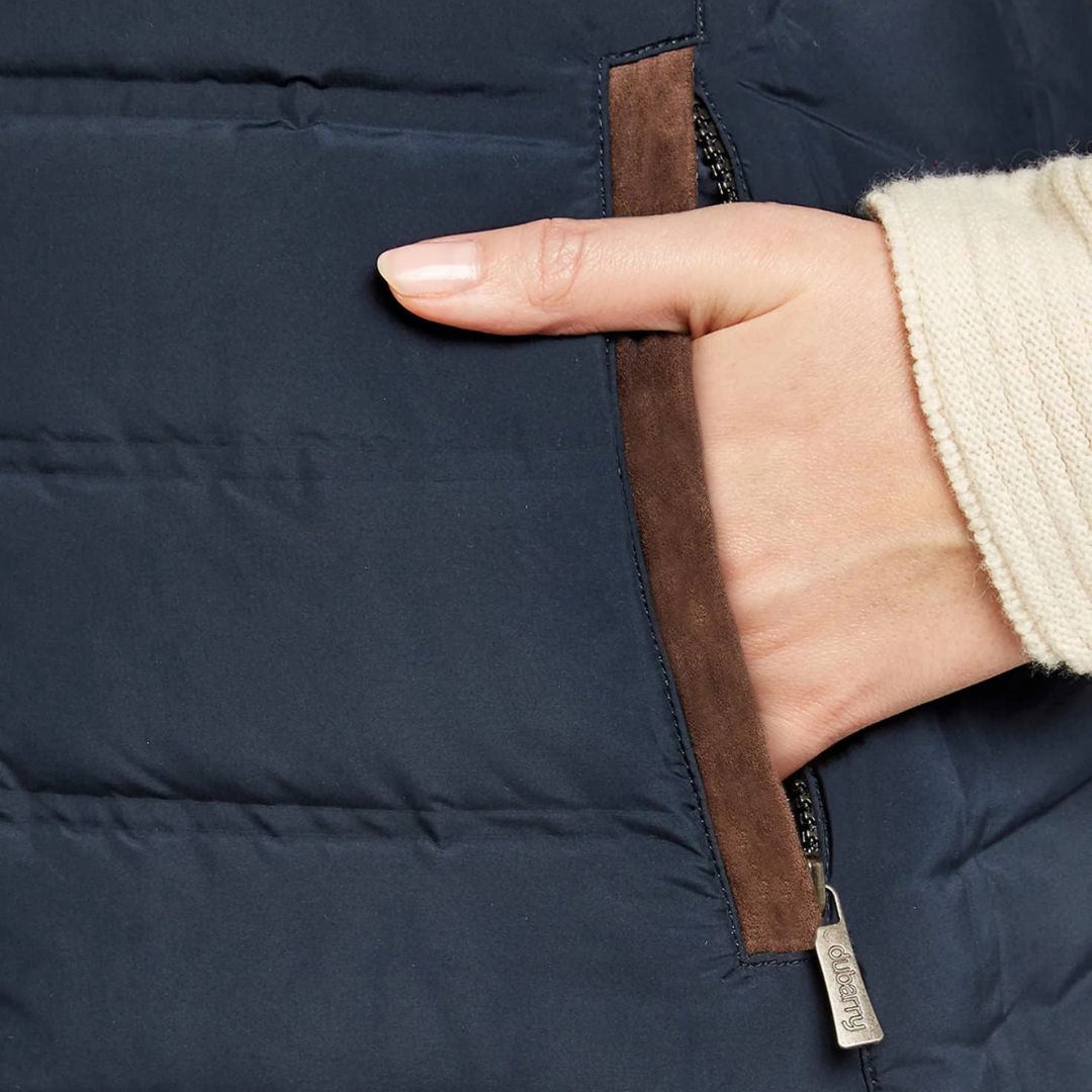 Hand opening a navy blue jacket with a brown zipper