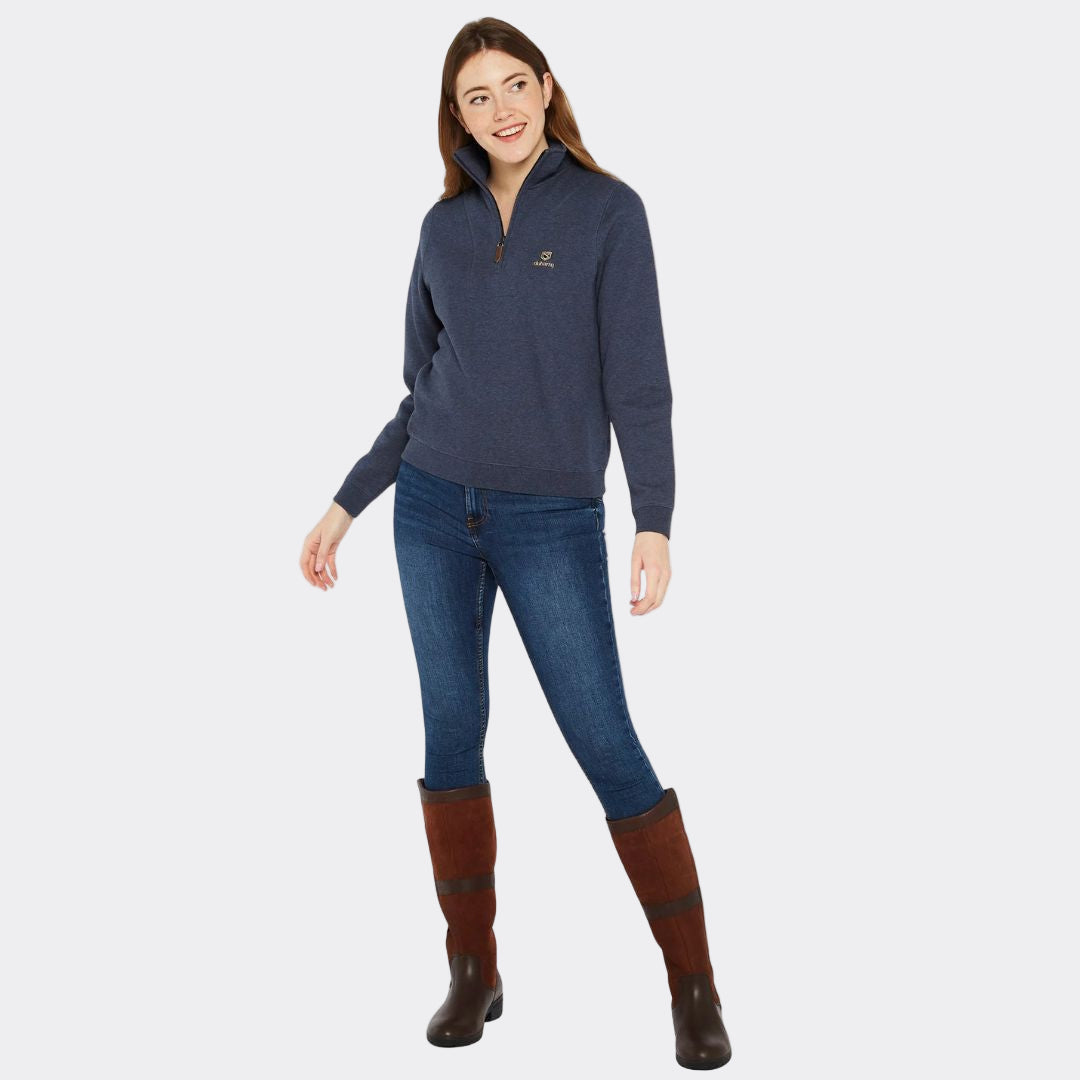 Woman wearing a navy blue sweater, jeans, and brown boots on a white background