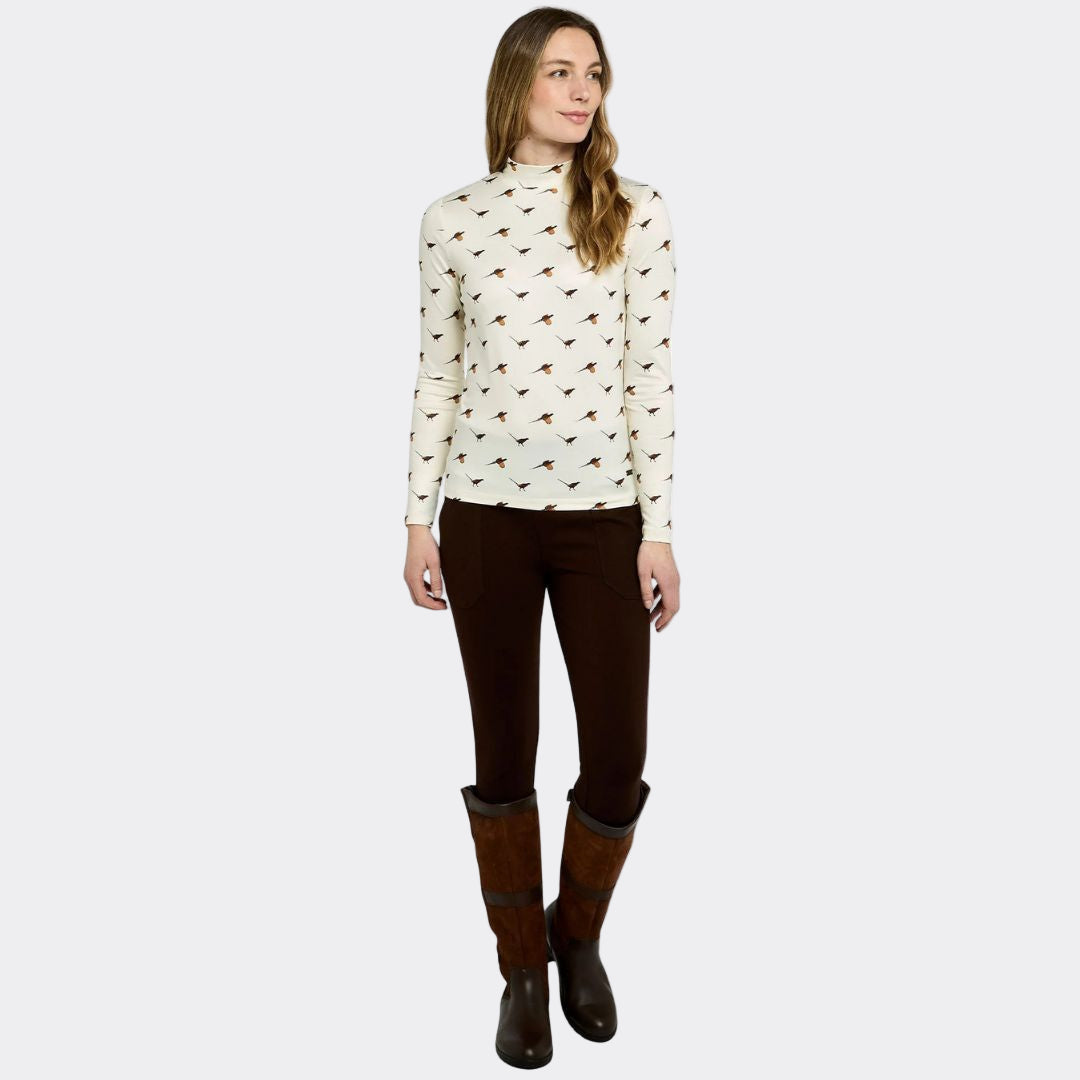Woman wearing a patterned blouse, brown pants, and boots on a white background