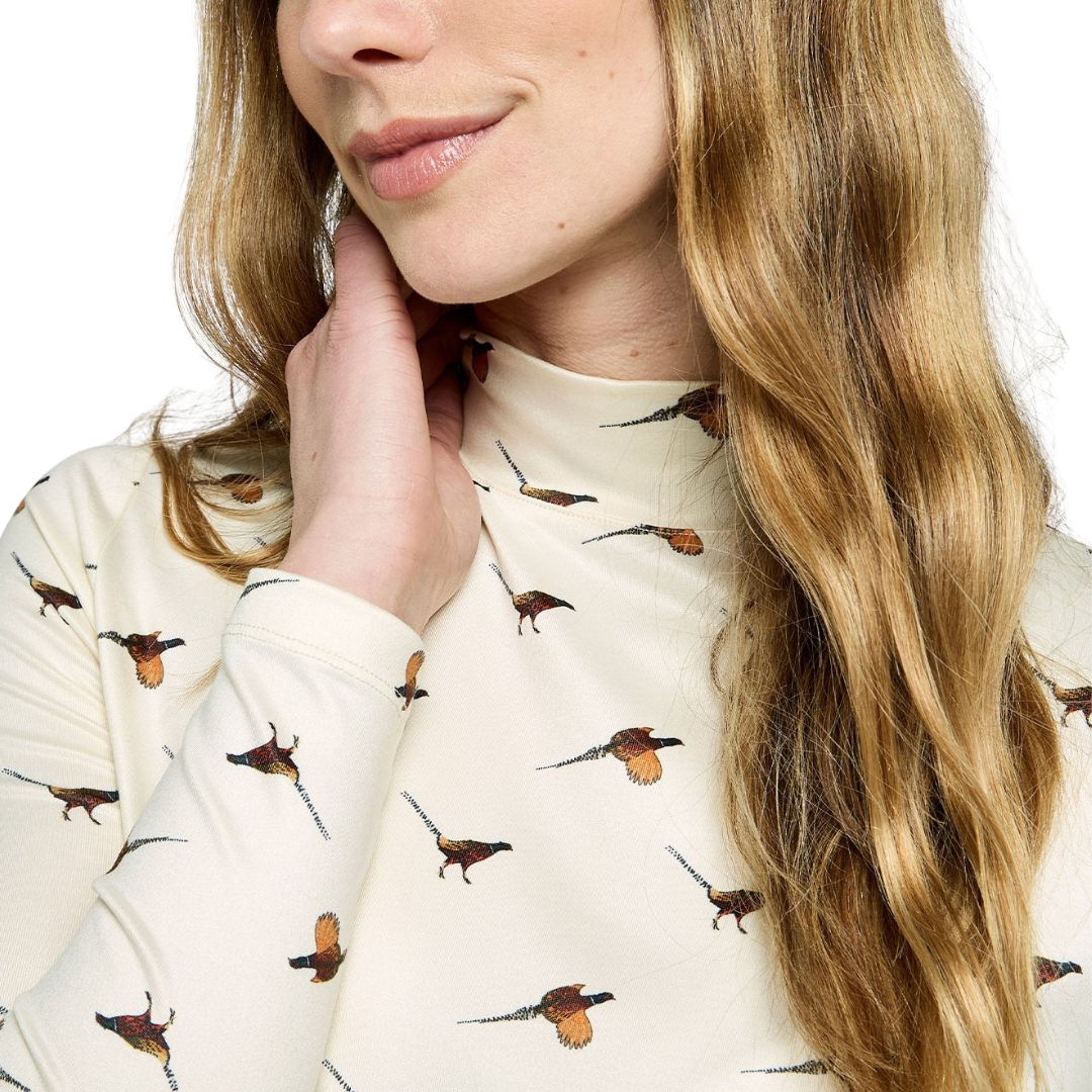Woman wearing a cream-colored sweater with bird pattern, close-up of face and sweater.