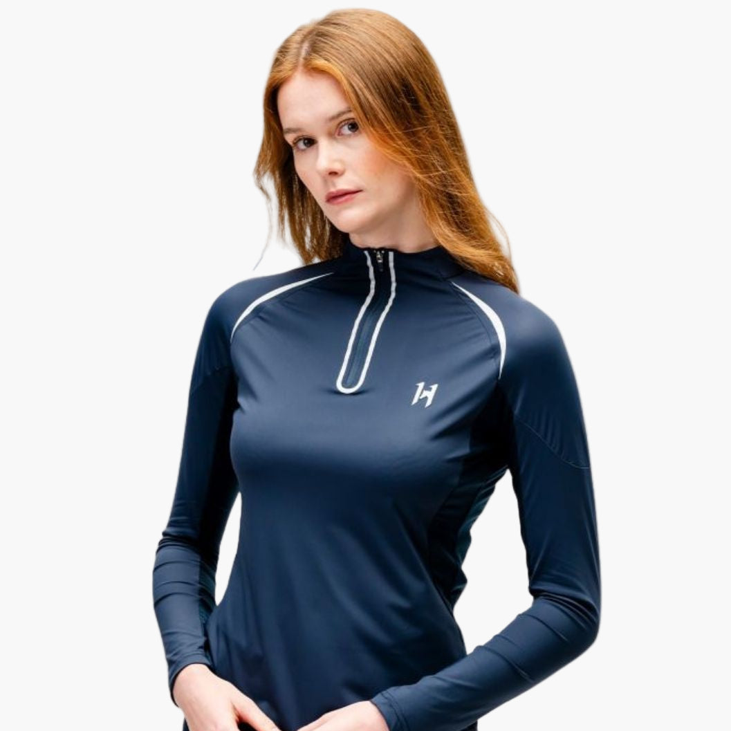 Woman wearing a navy long-sleeve athletic top with a white zipper on a white background