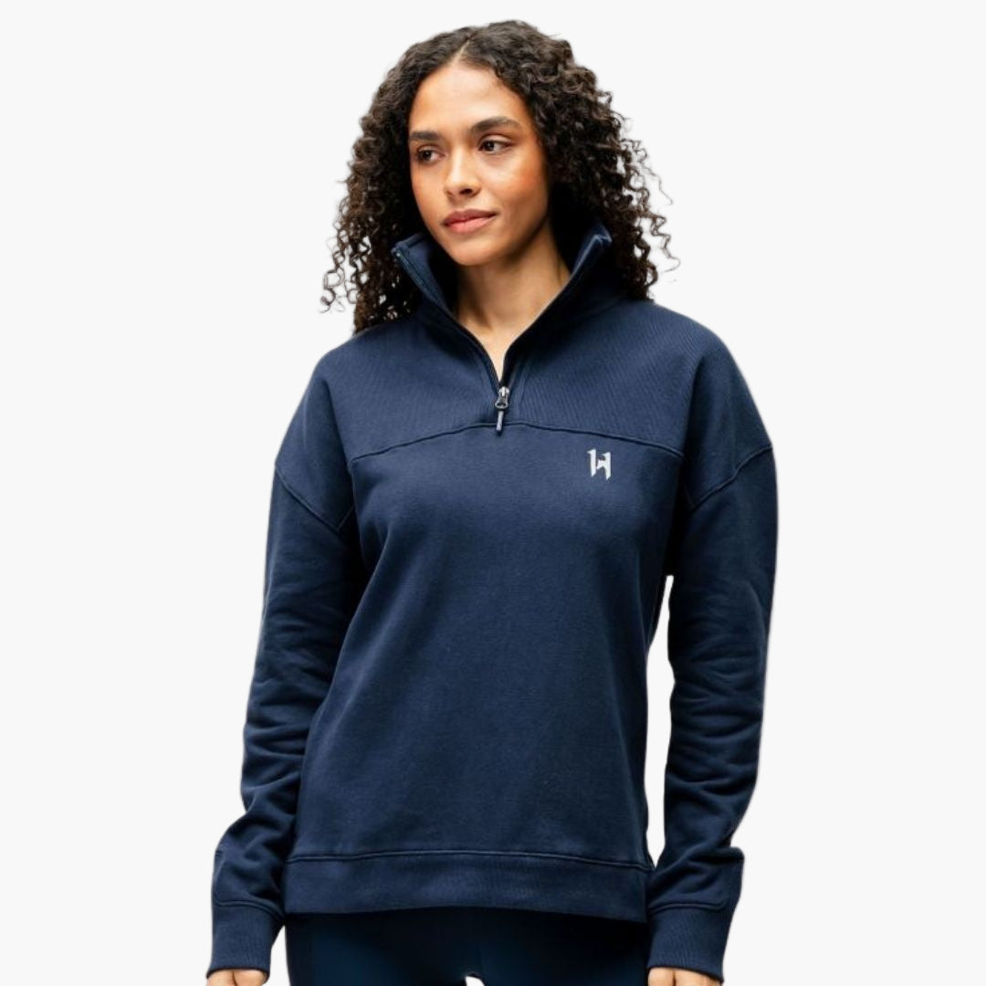 Woman wearing a navy blue pullover with a logo on a white background