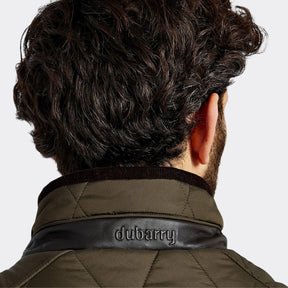 Person wearing a green jacket with 'Dubarry' branding on a white background