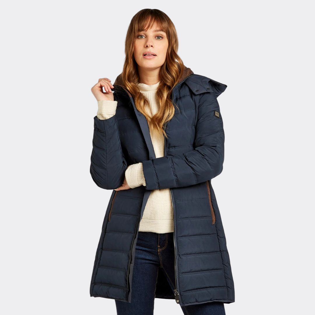 Woman wearing a navy blue puffer coat on a white background