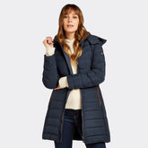 Woman wearing a navy blue puffer coat on a white background