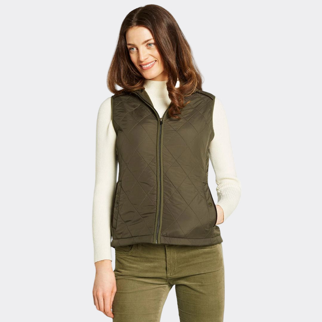 Woman wearing a green quilted vest on a white background