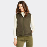 Woman wearing a green quilted vest on a white background