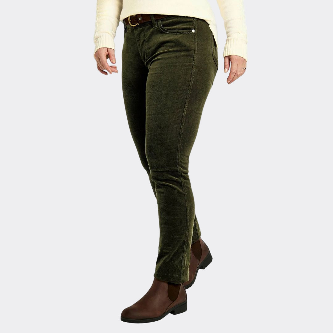 Person wearing green corduroy pants and brown shoes on a white background