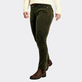 Person wearing green corduroy pants and brown shoes on a white background