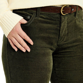 Person wearing olive green pants with a brown belt on a white background