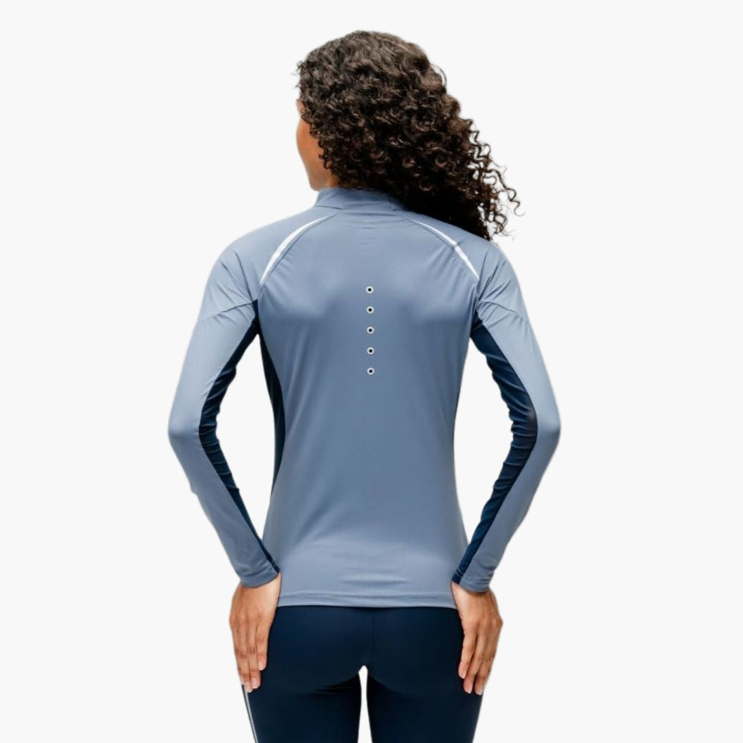 Woman wearing a gray long-sleeve athletic top with buttons on a white background