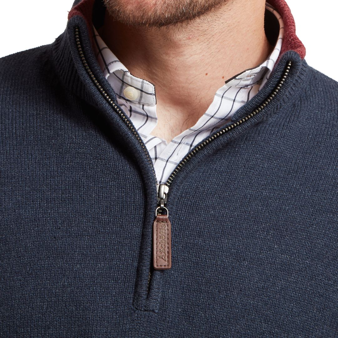 Navy blue zip-up sweater with a leather patch on a white background