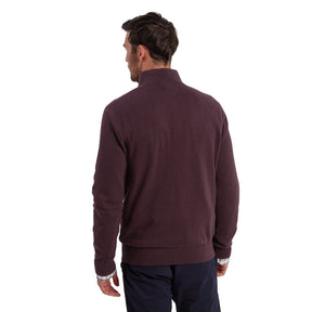 Man wearing a maroon half-zip sweater on a white background
