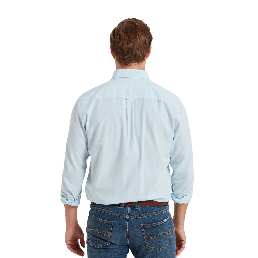 Man wearing a light blue shirt and jeans on a white background
