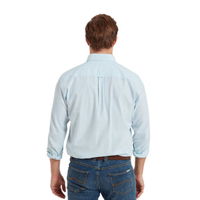 Man wearing a light blue shirt and jeans on a white background