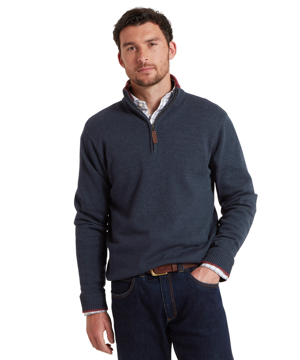 Man wearing a navy blue quarter-zip sweater and dark jeans on a white background