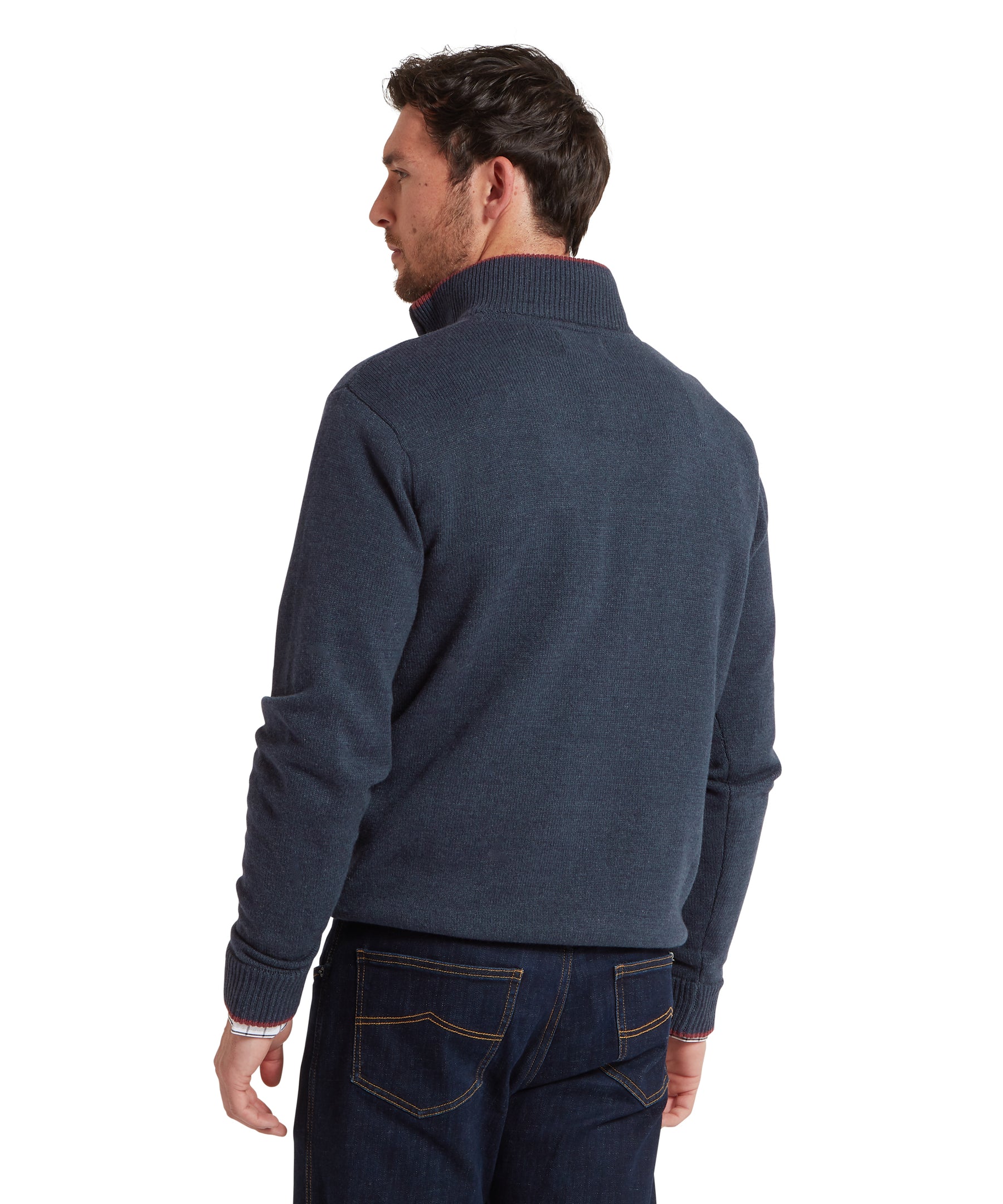 Man wearing a dark blue sweater and jeans on a white background